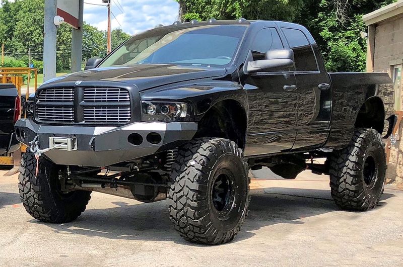 Black lifted 3rd gen Ram on a Dodge Off Road 6-inch suspension system, parked in a gravel lot