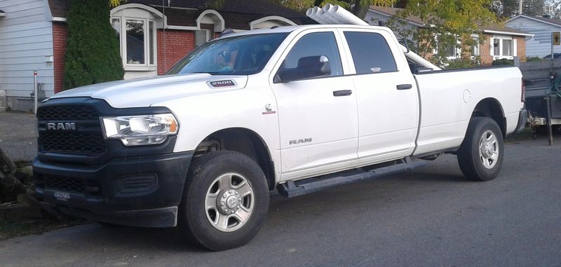 White 2020 Ram 2500 Cummins crew cab parked by a house